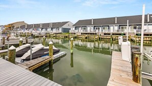 A marina with docked boats and a row of waterfront cabins. - Blue Horizon at Old Port (Ocean City)