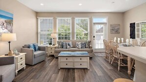A spacious living room with a sofa, coffee table, and dining area.