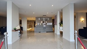 A hotel lobby with a reception desk, a seating area, and a reception counter. - Hams Apartments (Duba)