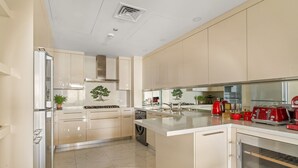 A modern kitchen with beige cabinetry, a stainless steel refrigerator, a built-in oven, and a sink. - Al Dabas - 707 2BD (Dubai)