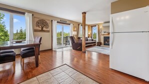 A spacious living area with a dining table, chairs, a sofa, and a fireplace.