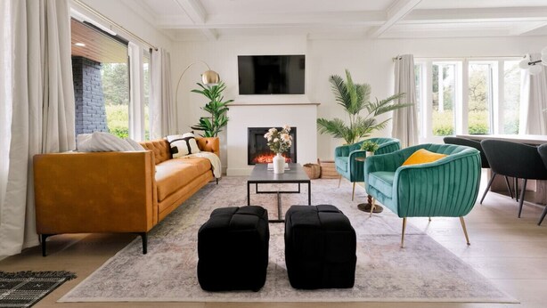 En moderne stue med sofa, stole, sofabord og pejs.