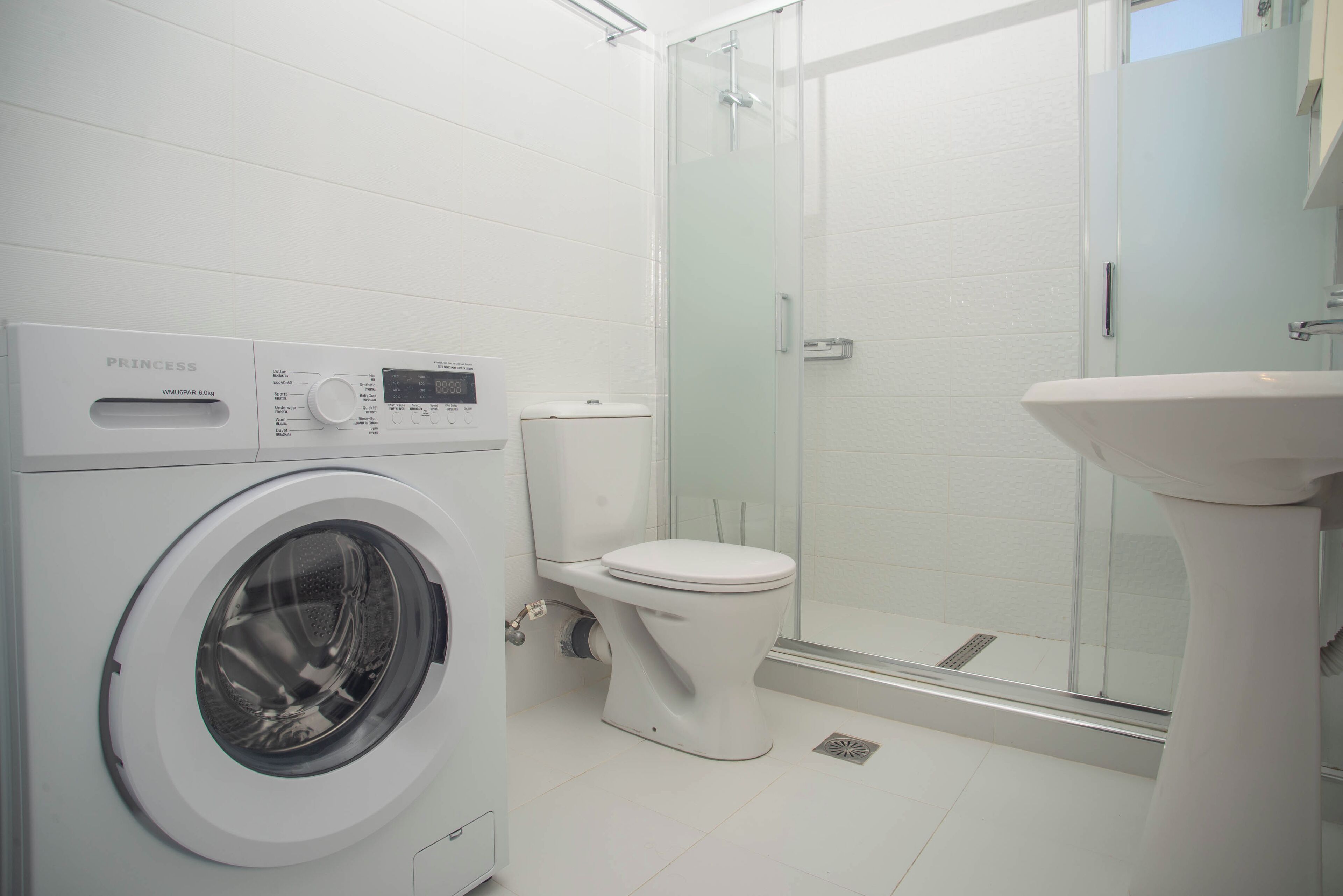 Panorama appartement | Badkamer | Een douche, een haardroger, handdoeken, zeep