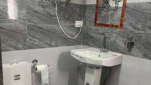 A bathroom with a toilet, sink, and shower. - Universal Comfort Guest House (Kargil)