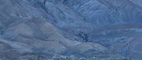 A town nestled against snow-capped mountains with buildings in the foreground.