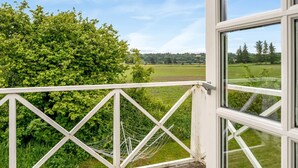 A balcony with a white railing overlooking a lush green landscape and a clear blue sky. - "Elza" - 2.5km from the sea by Interhome (Fjerritslev)