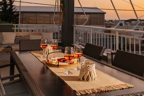Un comedor con una mesa larga dispuesta para una comida, mostrando una variedad de platos y bebidas.