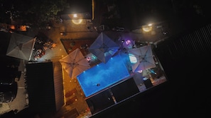 Una piscina al aire libre, sombrillas, sillones reclinables de piscina