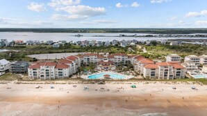 A coastal hotel with multiple buildings, a beach, and a swimming pool. - Sunny Side Up at Villa Capriani Resort | Unit 108A | North Topsail Beach, NC (North Topsail Beach)
