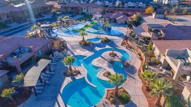 A residential area with a swimming pool, lounge chairs, and a water park. - Entire Home Paradise Pools 2 King Suites (Ivins)