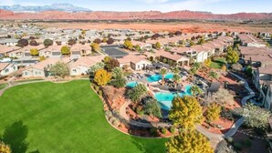 A residential area with houses, a swimming pool, and a large green lawn. - Entire Home Paradise Pools 2 King Suites (Ivins)