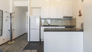 Una cocina moderna con armarios blancos, encimera negra y un salpicadero con diseño.