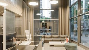A modern interior with a sofa, coffee table, and a glass partition.