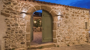 Un edificio de piedra con una puerta verde y un arco.
