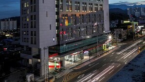 A high-rise hotel with multiple floors and balconies, a prominent sign at the top, and a well-lit entrance area. - Hotelaround Sokcho (Sokcho)