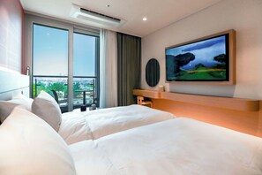Een hotelkamer met twee bedden, een groot raam met uitzicht op de stad, een flatscreen televisie aan de muur en een moderne airconditioning.