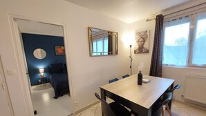 Un comedor con una mesa, sillas, una lámpara y un espejo.