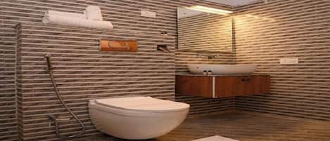 A bathroom with a stone-patterned wall, a toilet, a sink, and a mirror.