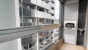 Eine moderne Wohnung mit Balkon, Backofen und Blick auf die Stadtlandschaft.