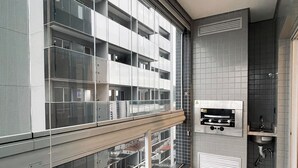 Eine moderne Wohnung mit Balkon, Backofen und kleiner Küchenzeile.