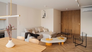 Ein modernes Wohnzimmer mit einer Couch, einem Couchtisch und einem Esstisch.