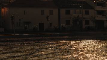 Un atardecer sobre un cuerpo de agua con edificios al fondo.