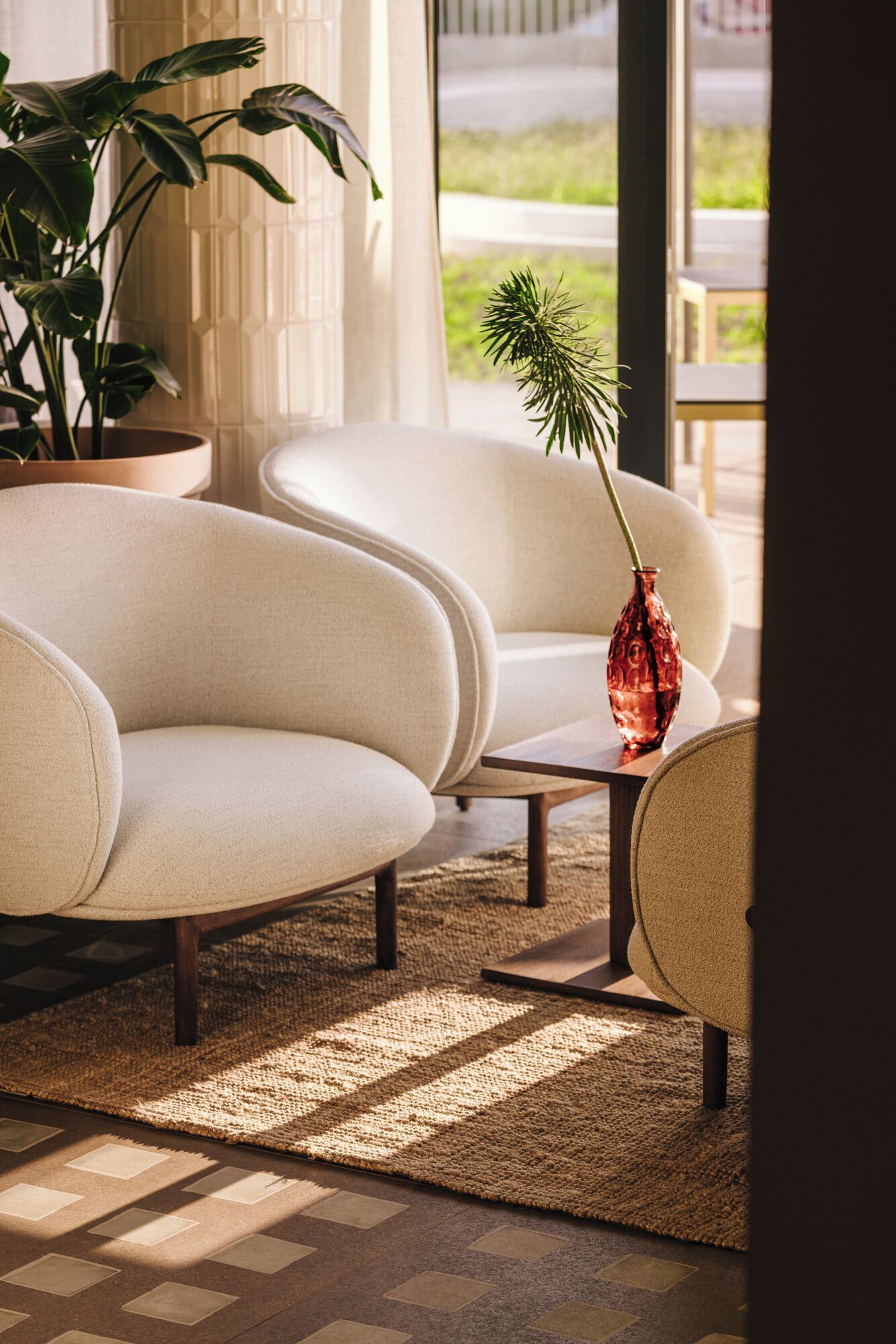 A modern living room with a beige sofa, a small table, and a decorative vase.