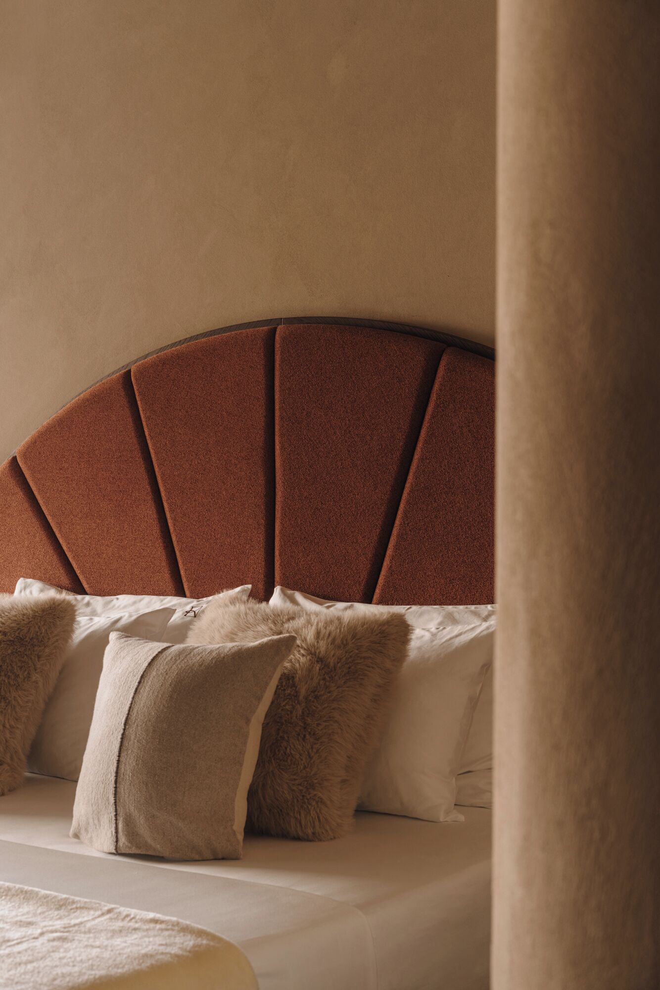 A bed with a headboard, pillows, and a bedside table.
