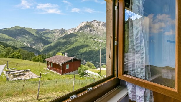 A window with a view of a mountain landscape, a wooden structure, and a fence. - Casa Clelia Centovalli With Private Garden (Centovalli)
