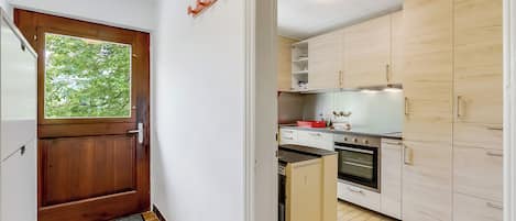 Una cocina compacta con armarios de madera, horno empotrado y refrigerador.