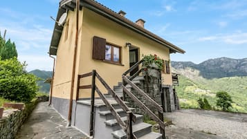 Una casa con escalones de piedra, una puerta y una ventana con persiana.