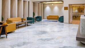 A spacious lobby with a marble floor, modern furniture, and a chandelier. - Gir Aatithya Clarks Inn  (Talala)