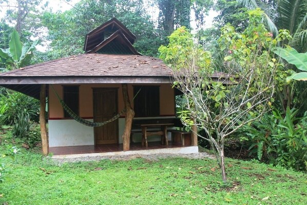 A small, single-story building with a tiled roof and a porch area.