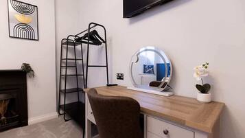Un dormitorio moderno con literas, un escritorio con espejo, un televisor de pantalla plana y una chimenea.