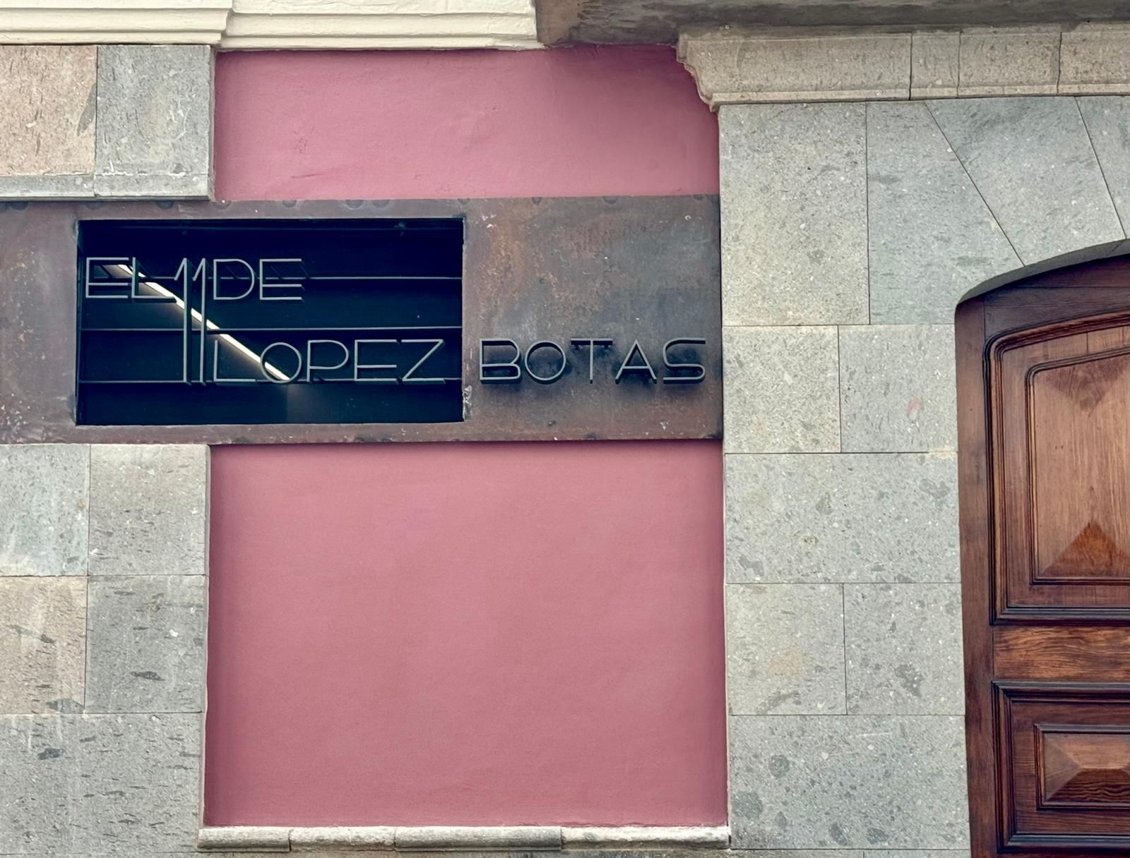 A sign with the name "EMILIO LOPEZ BOTAS" mounted on a building facade.