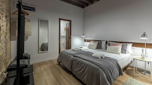 A bedroom with a large bed, bedside tables, a wardrobe, and a mirror.