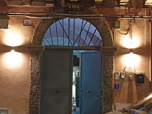 An arched entrance with a metal mesh design, a door, and two wall-mounted lights. - Catania Centro Storico Soha Home 2 (Catania)
