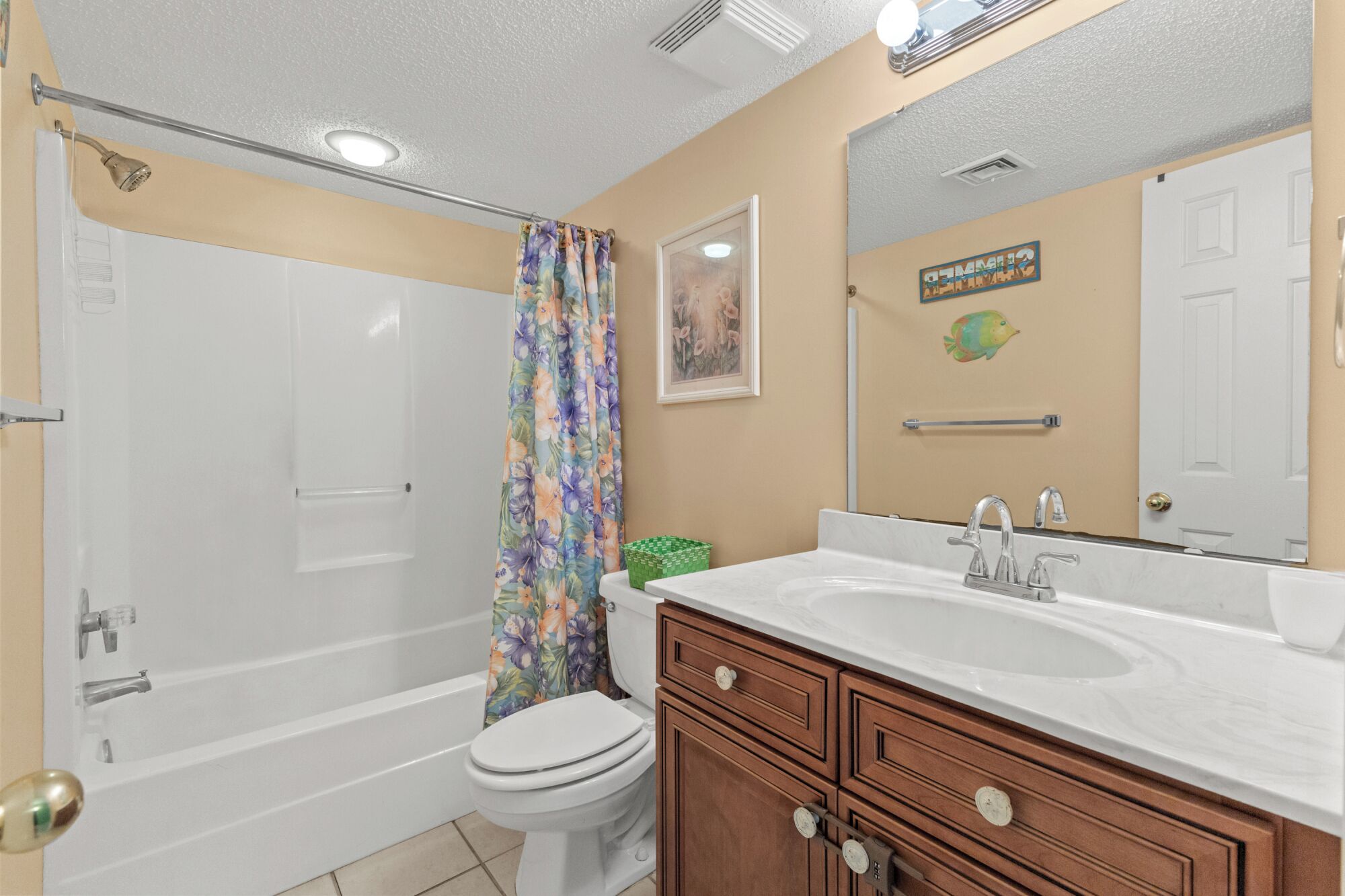 A bathroom with a bathtub, toilet, and a vanity with a sink.