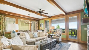 A spacious living room with a large sofa, a coffee table, and a balcony with a view. - Chalakee Lodge CJ-3- Mountain View, Gated Resort, Indoor/Outdoor Pools & Hot Tub (Boone)