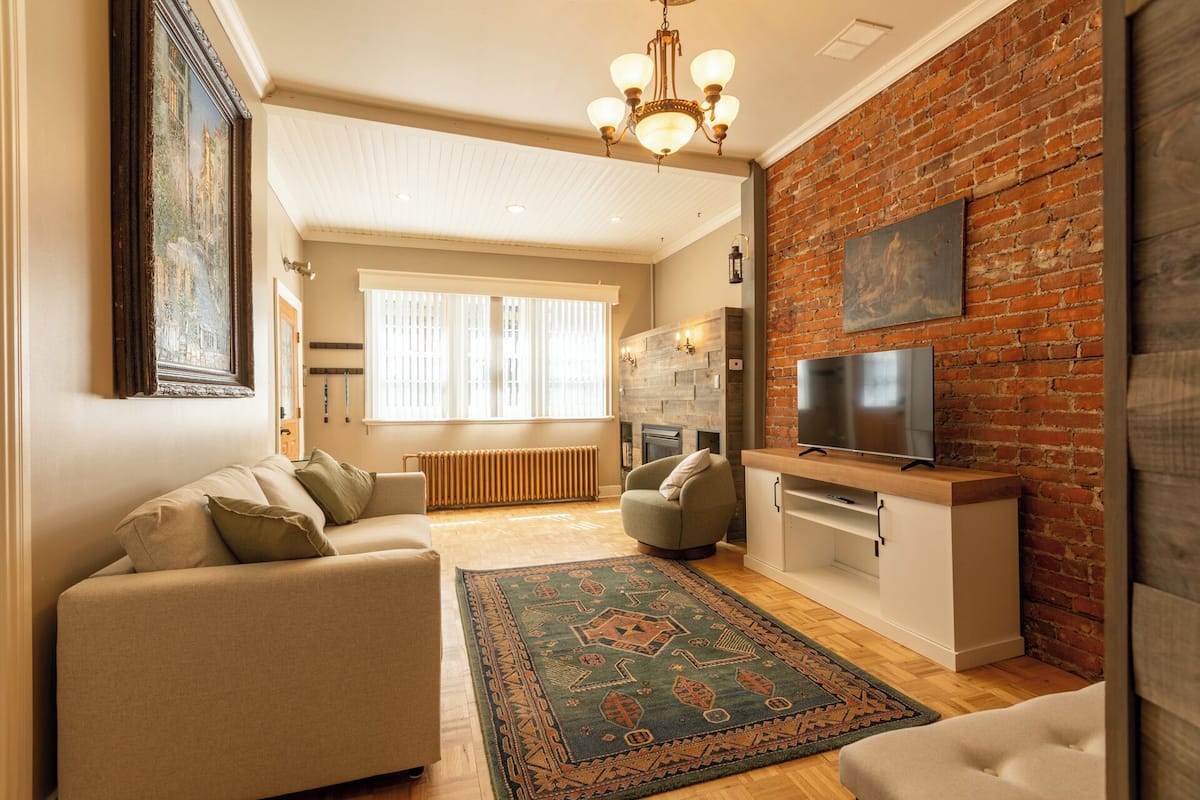 A spacious living room with a large TV, a fireplace, and a cozy seating area.