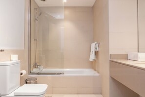 Ein modernes Badezimmer mit Toilette, Waschbecken und Dusche.
