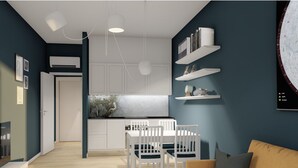 A modern living room with a sofa, a dining table with chairs, and a kitchen area with white cabinets and a marble backsplash. - Studio for 3 guests in Turin (Torino)