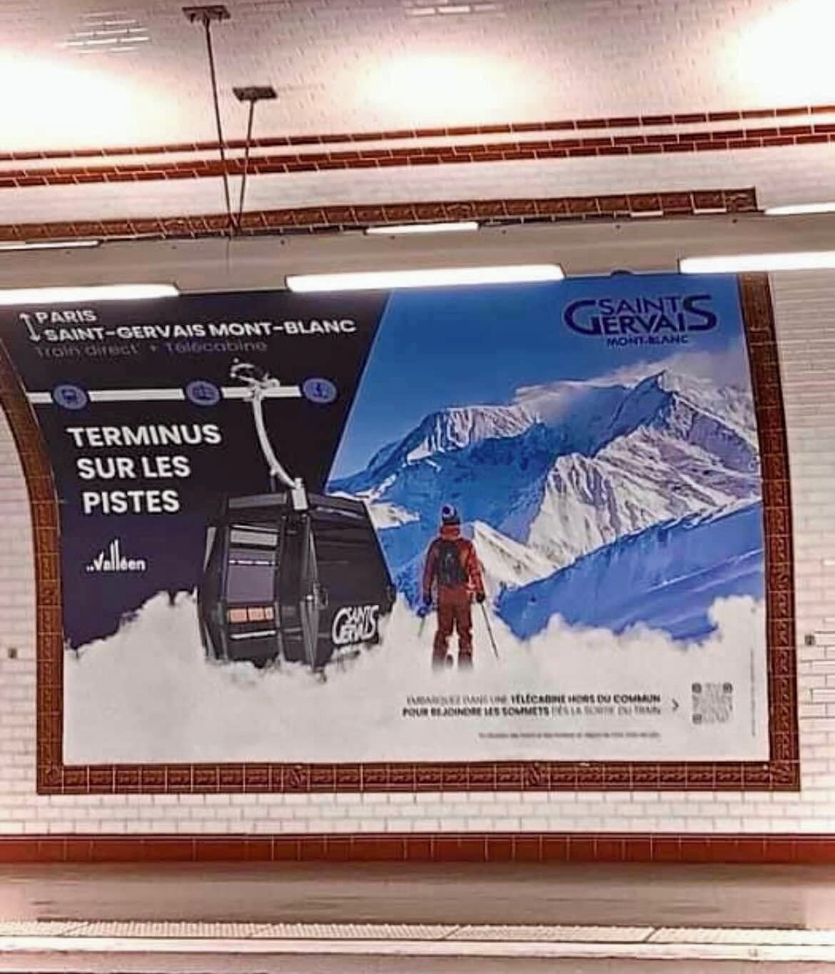 Une grande affiche publicitaire pour une station de ski, avec une montagne enneigée en arrière-plan.
