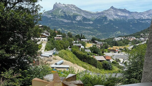 Un paisaje montañoso con un pueblo en el valle.