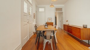 Un comedor con mesa de madera, sillas e iluminación colgante moderna.