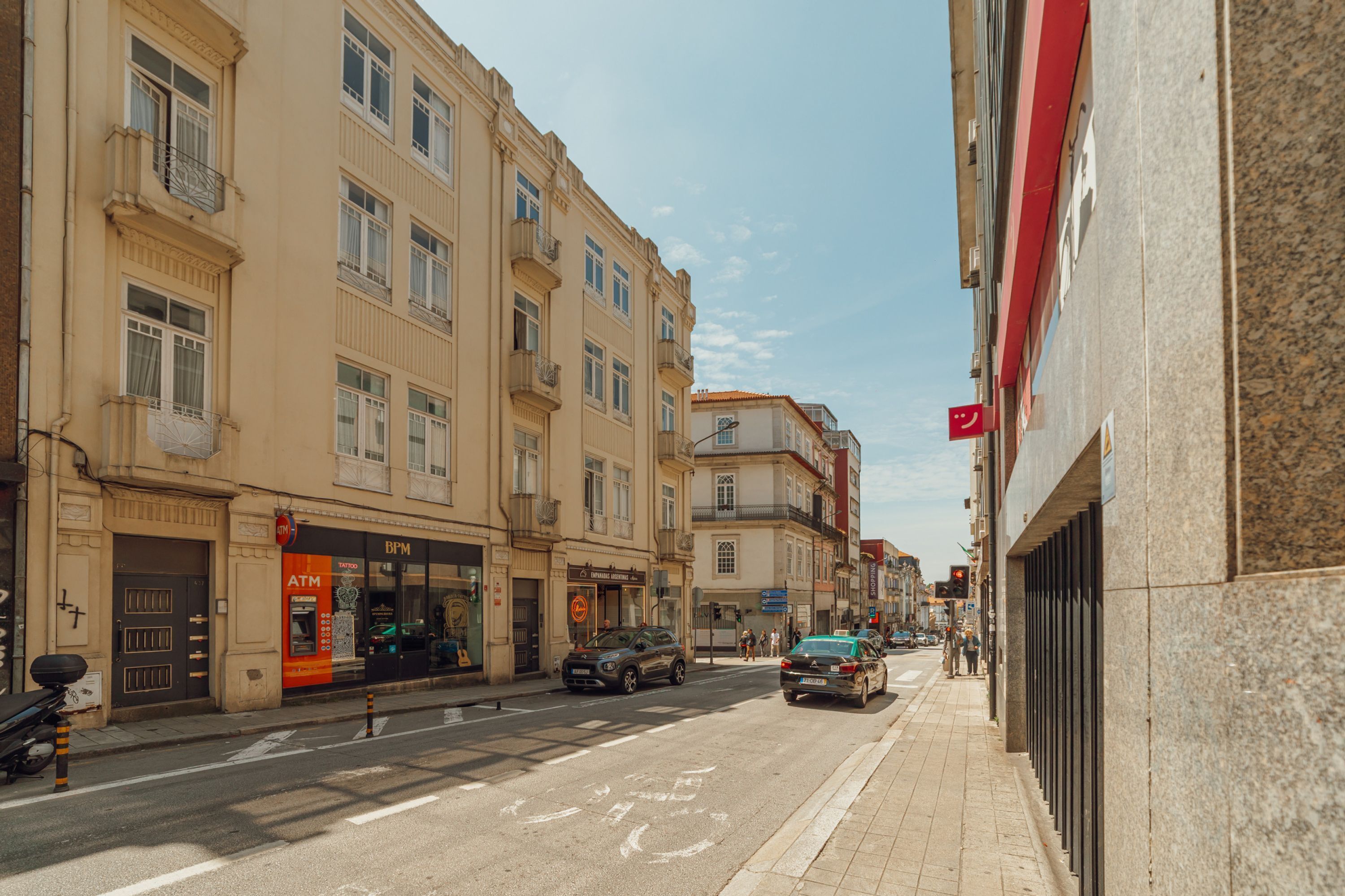 Una strada con edifici, un'auto e un motociclo.