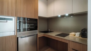 A compact kitchen with a built-in oven, a sink, and a coffee maker. - Via Monte Apartments by Olala Homes (Madrid)