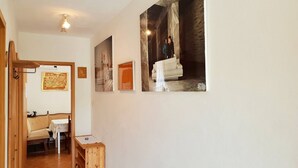 Un pasillo con un banco de madera, una mesita y un mapa enmarcado en la pared.