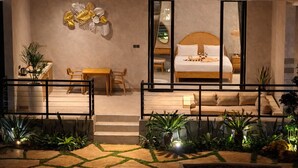 Une chambre d’hôtel moderne dotée d’un grand lit, d’un coin repas et d’un balcon agrémenté de plantes.