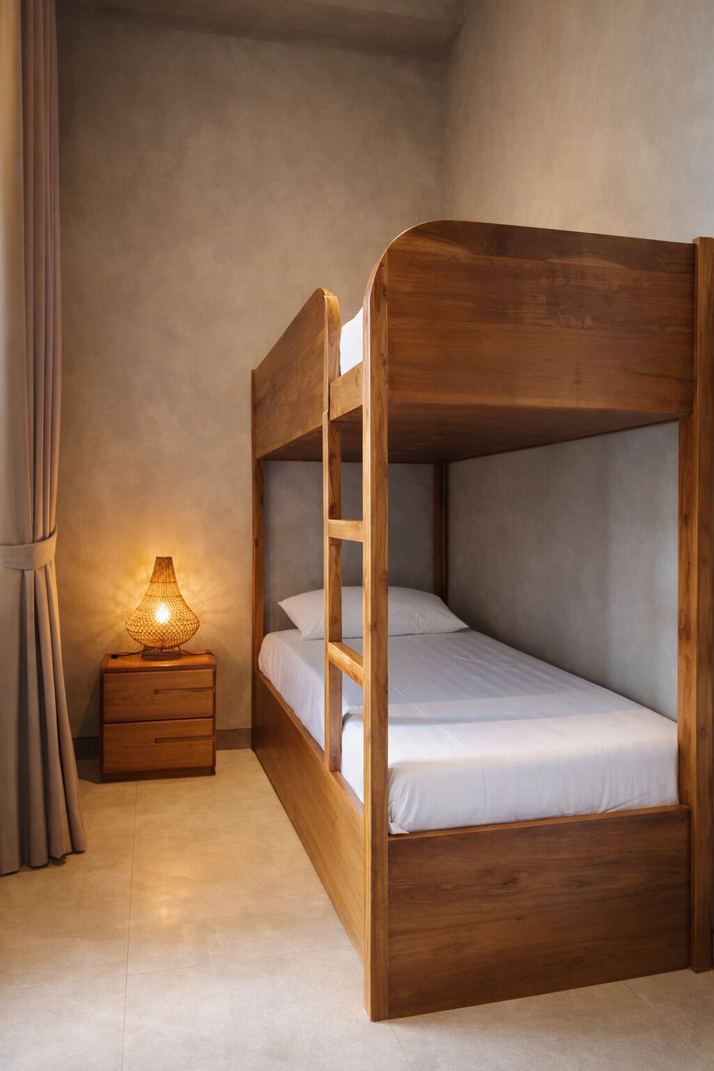 A bunk bed with a wooden frame, a bedside table with a lamp, and a curtain.